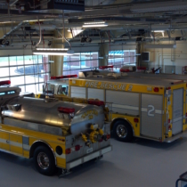 three fire trucks parked inside of the huguenot volunteer fire department building